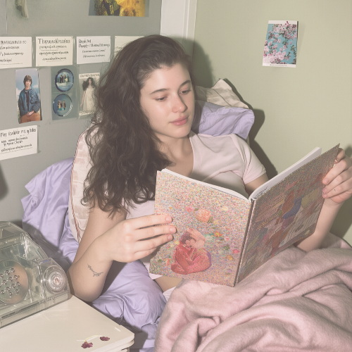 Woman reading a book in bed with a cozy bedroom setting